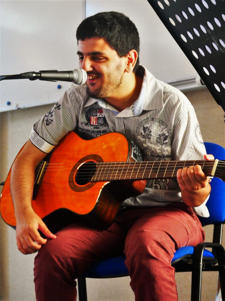 Cem tout sourire à la guitare et au chant