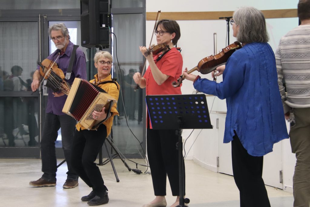 Le groupe Tourmaline au milieu de la salle, avec Dominique Tavernier à la nickelharpa, Nathalie Rochet à l'accordéon, Marjolaine Suchel et Chantal Roussel aux violons