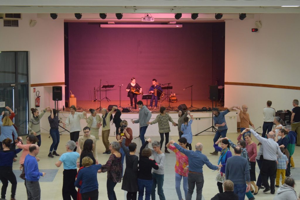 la salle Jean Couty pleine de danseurs qui dansent devant un groupe de musiciens sur scène : le Duo ligérien